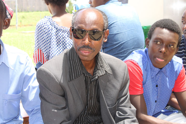 Papa na murumuna ba Arthur bategereje ko asohoka mu kibuga cy'indege cya Kigali.