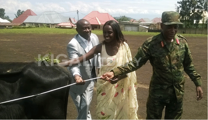 Br Gen Murokore hamwe na Tugirumwami, Umuyobozi wa COPIBU, bashyikiriza inka Nyiransabimana.