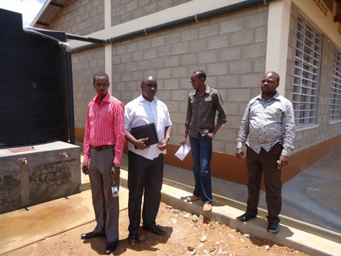 Abahagarariye Plan Rwanda bamurikira abahagarariye akarere inyubako bubatse.