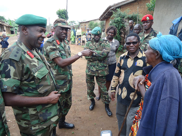 Abayobozi b'Ingabo barimo Lt Gen Fred Ibingira (wambaye isaha) n'umuyobozi w'akarere ka Nyaruguru, baganira n'abaturage bahawe amazu.