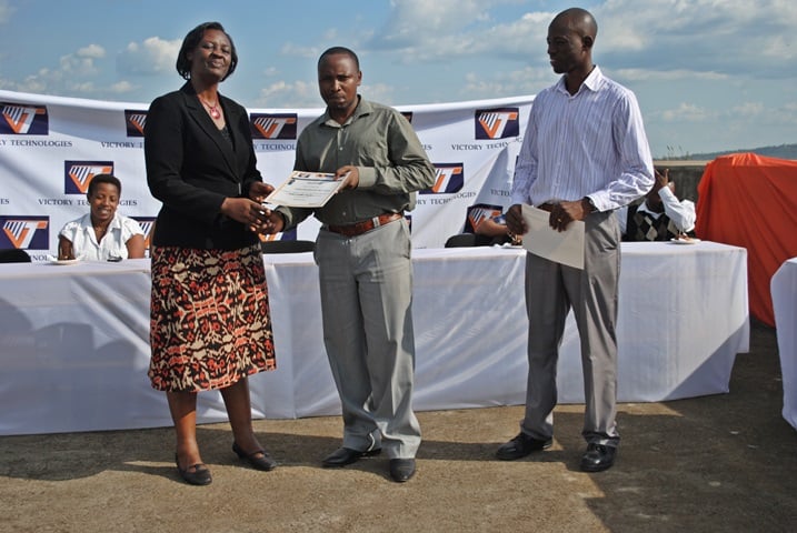 Uwari uhagarariye RDB na Bizimana (iburyo) bashyikiriza umwe mu bauguwe impamyabushobozi.