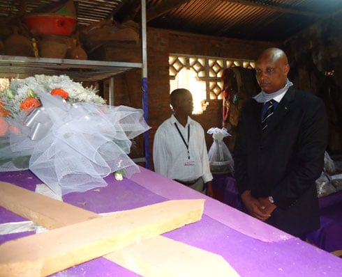 Kalima Jean Malic umuyobozi w'ishyirahamwe ry'abacukuzi b'amabuye ashyira indabyo ku mva ishyinguyemo abazize Jenoside.
