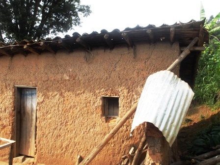 Mbere yabanaga n'abana n'ibikoresho n'amatungo mu kazu k'ibyumba bibiri.