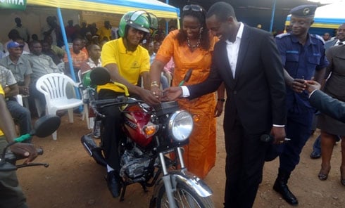 Umuyobozi mukuru w'Umurimo Anna Mugabo na Nzitunga Evode uyobora Sytramorwa bashyikiriza moto umwe mu baremewe.