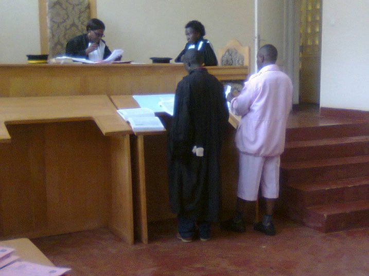 Mugabe Kwizera Victory hamwe n'umwunganira bari mu rukiko.