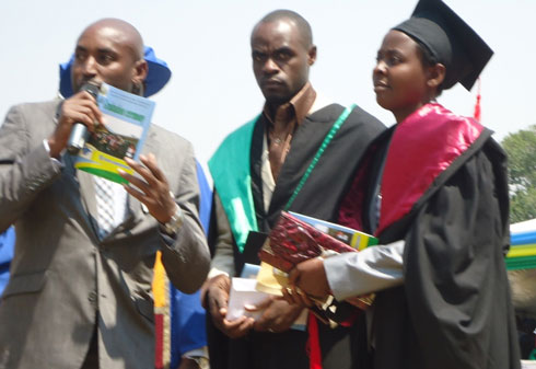 Nzamwitwkuze Velentine ahabwa igihembo cy'ibihumbi 100 na Fina Bank kuko yarushije abandi amanota mubahawe impamyabumenyi bose.