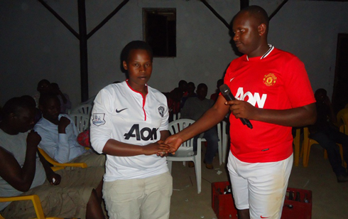 Perezida w'abafaba b'ikipe ya Manchester United Gakuru James ashyikiriza umugore w'umwe mubafana uherutse kwitaba Imana inkunga.