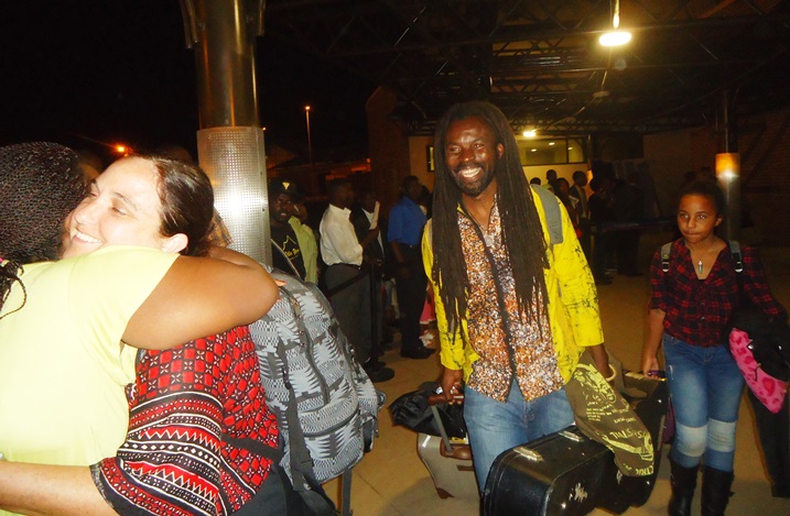 Umuhanzi Dawuni, amaze kururuka indege i Kanombe yakiriwe n'Umukozi wo ku rwibutso rwa Jenoside rwa Kigali( aha madamu wa Dawuni niwe basuhuza)