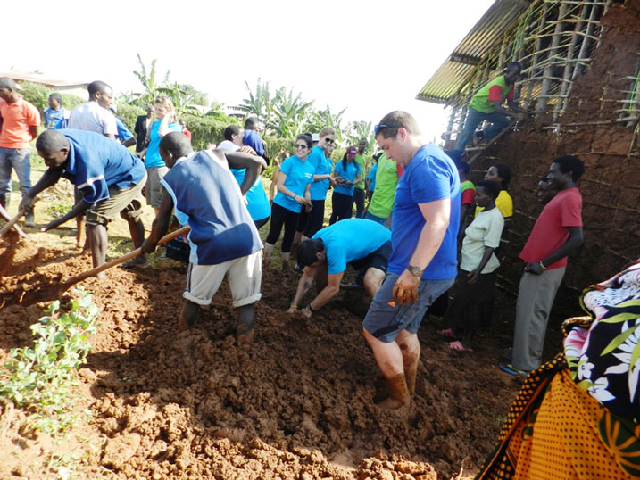 Umuganda wari urimbanyije. Aba bazungu na bo bakataga icyondo cyo kurobeka inzu zubakirwa iyi miryango itatu y'Abanyarwanda birukanwe muri Tanzaniya.