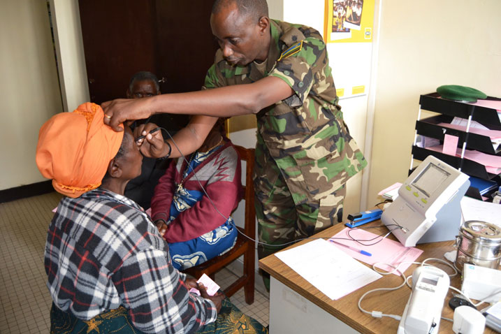 Umuganga w'umusirikare arimo kuvura umubyeyi urwaye ishaza.