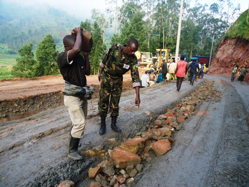 Abakozi bahawe akazi na RDF bashyiraga amabuye mu muhanda kugira ngo ukomere imodoka nini zihite nta kibazo.