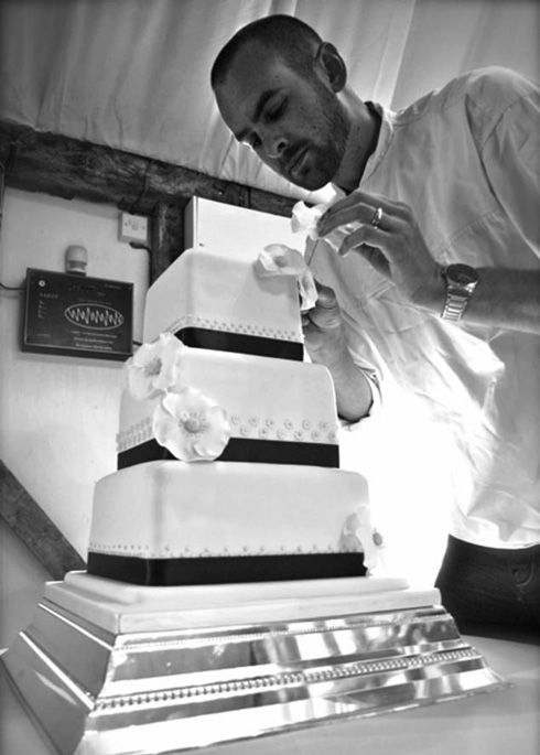 Umunyarwenya Chris Holmes arimo gutaka gateau.