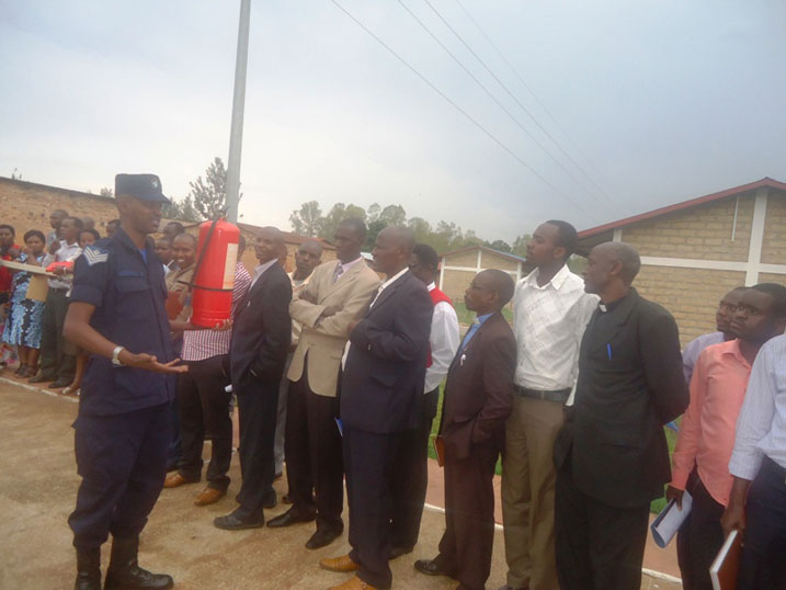 Umupolisi wo mu ishami rishinzwe guhangana n'inkongi z'umuriro yasobanuriye abahuguwe imikoreshereze ya Kizimyamwoto.