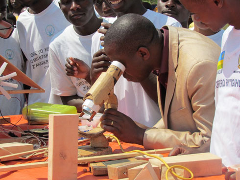 Umuyobozi w'akarere ka Ngoma arebera muri microscope yakozwe n'intore yo mu karere ayobora.