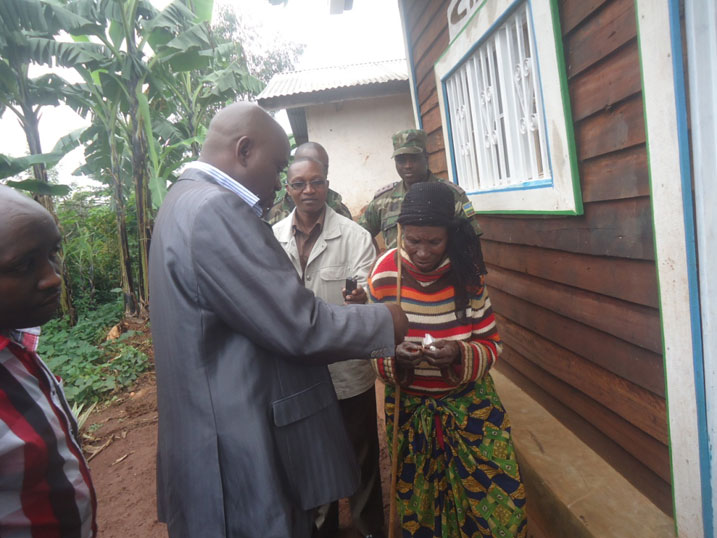 Umuyobozi w'akarere ka Rusizi w'ungirije ushinzwe imibereho myiza y'abaturage aha umukecuru urufunguzo rw'inzu yubakiwe n'Inkeragutabara.