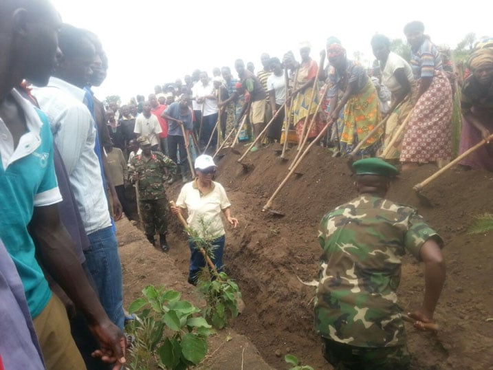 Umuyobozi wa REMA (wambaye ingofero y'umweru) yifatanyije n'abaturage guca imiyoboro y'amazi itangira isuri ngo itajya mu kiyaga.