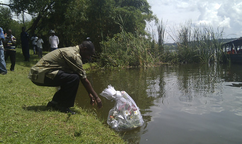 Uwimana Nehemie uyobora akarere ka Rwamagana ashyira indabyo mu mazi ya Muhazi.