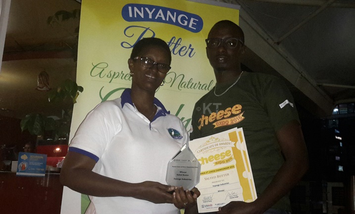 Abakozi b'uruganda Inyange bakiriye igikombe nyuma yo gushyira ku isoko amavuta y'inka atunganyije neza.