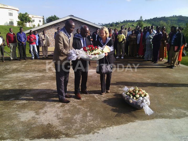 Abanyamuryango ba AMIR bashyira indabo ku rwibutso.