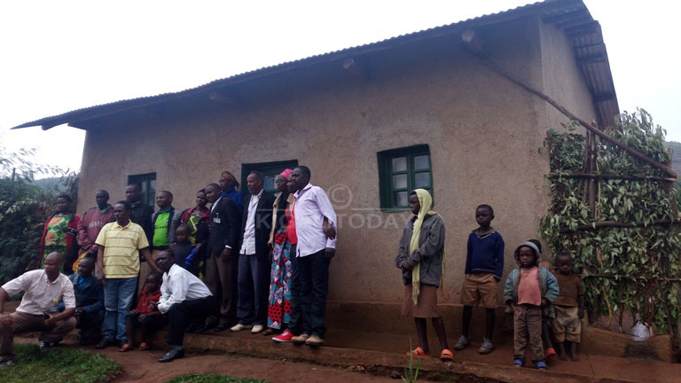Abari baje gutanga no kwakira inka zagabiwe Mukabutera bafatiye ifoto y'urwibutso imbere y'inzu abamo, ari na yo CIM yamusaniye muri 2015 