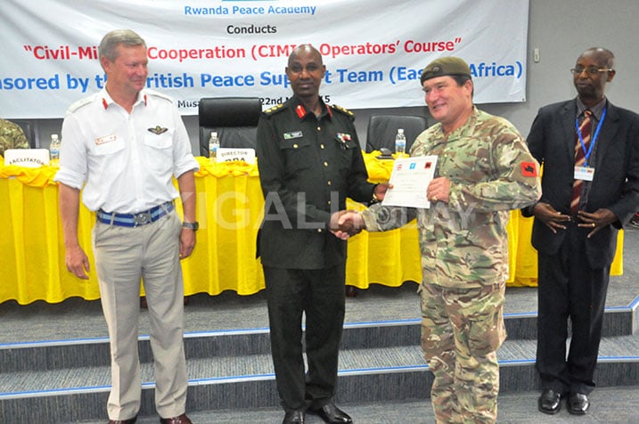 Col Rutaremara ahereza impamyabumenyi umwe mu bahuguwe.