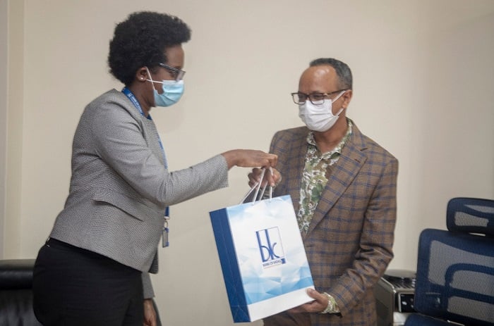 Dr Diane Karusisi wa BK ashyikiriza Teklay Teame wa Simba Supermaket impano ya Noheli, kubera gukoresha POS