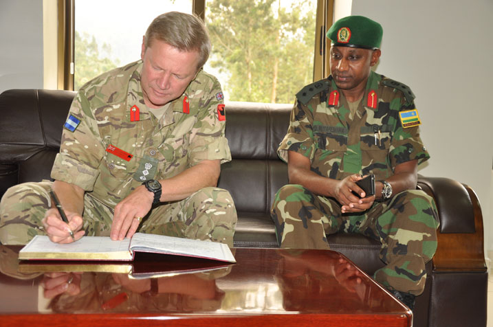 Col. Richard Leakey uyobora British Peace Support Team muri Afurika y'Uburasirazuba asinya mu gitabo cy'abashyitsi mu ishuri Rwanda Peace Academy.
