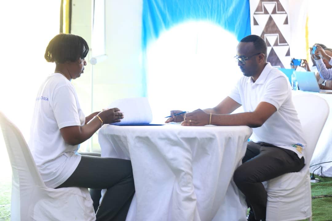 Umwe mu bayobozi asinya imihigo imbere ya Meya Mutabazi