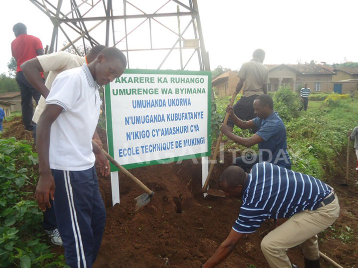 Guverineri w'Intara y'Amajyepfo, Munyantwari Alphone (utsindagira icyapa), afatanya n'abaturage b'Umurenge wa Byimana mu buryo bushya bw'umuganda batangije.