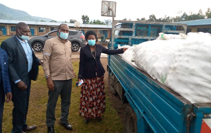 Gitifu w'Umurenge wa Kinigi (hagati) ndetse n'Umuyobozi w'Urugaga rw'Abikorerera (wambaye kositimu) bashyikiriza Gitifu wa Muko inkunga bageneye abaturage