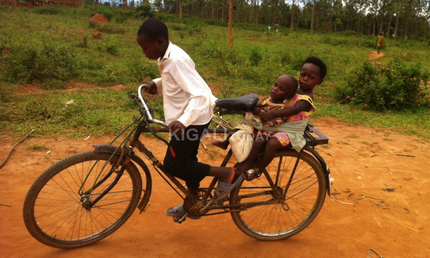 Umwana wo mu Karere ka Bugesera yaziritse barumuna be ku igare avuye kubakingiza (Photo by Egide Kayiranga).