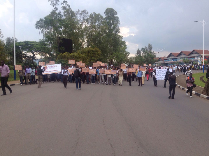 Abantu bari bafite ibyapa byanditseho ubutumwa butandukanye.