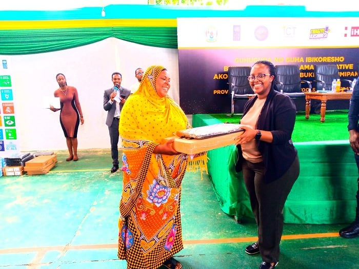 Esther Kunda ashyikiriza Umuyobozi wa Koperative mudasobwa