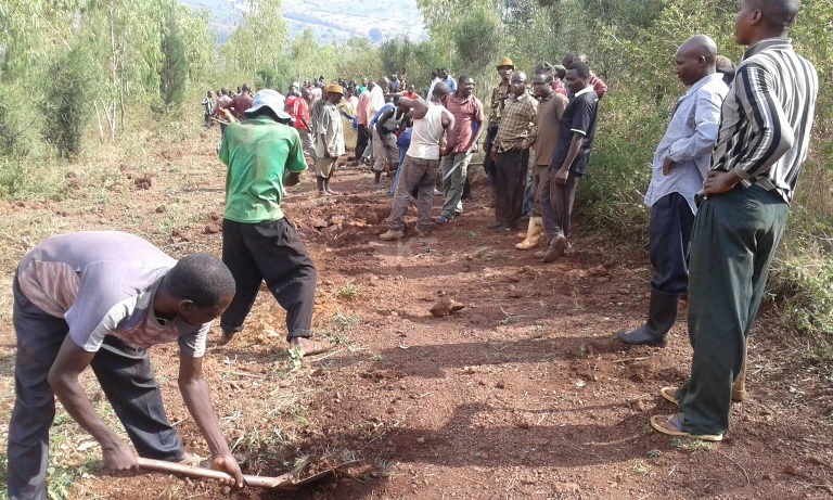 Abaturage bazindukiye mu gikorwa cyo gusibura umuhanda.