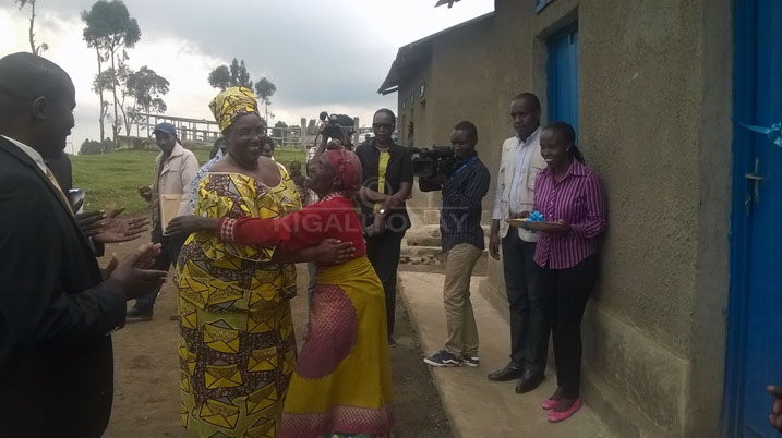 Minisitiri wa MIDIMAR ahoberana n'umwe mu baturage bahawe inzu 