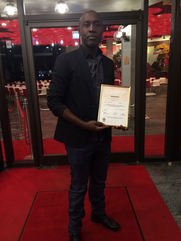 Olivier Karekezi yerekana impamyabumenyi y'ubutoza yabonye.
