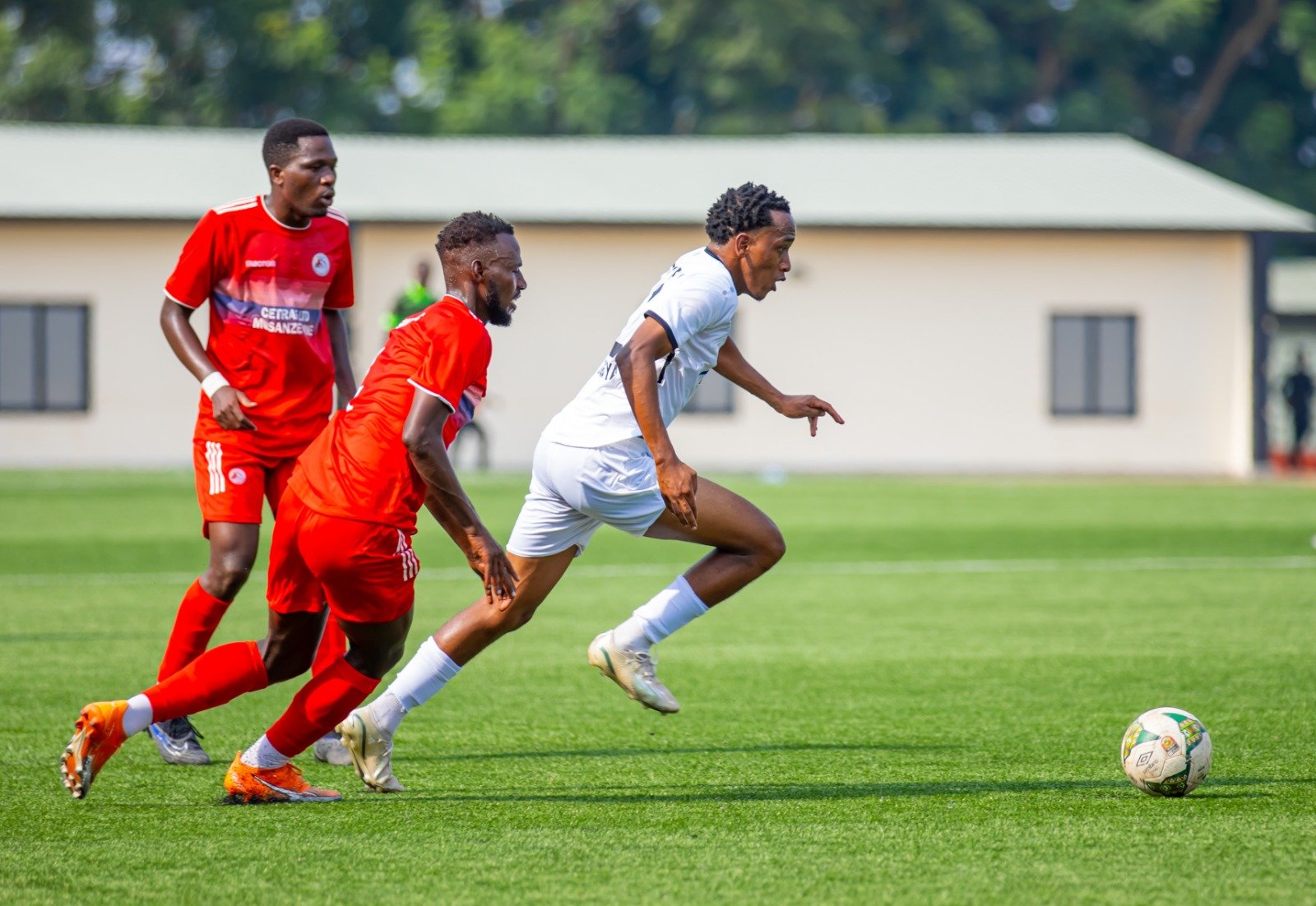 Kategaya Elia agerageza gutwara umupira abakinnyi ba Musanze FC 