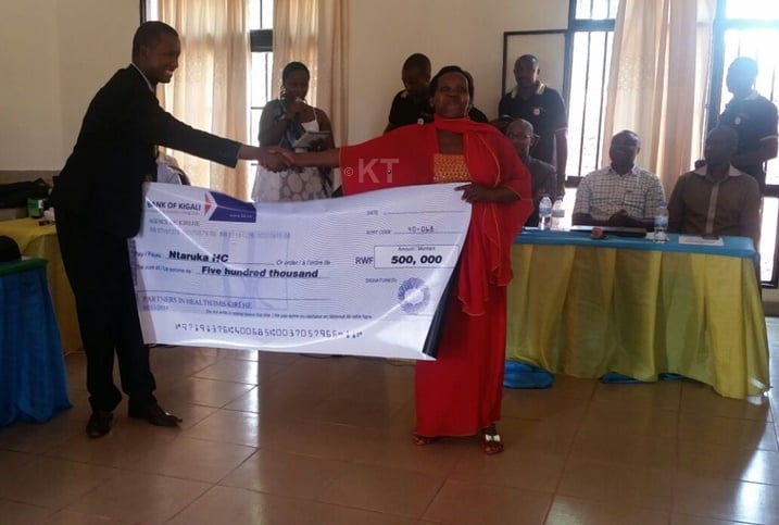 Umuyobozi w'Akarere ka Kirehe, Muzungu Gerald ashyikiriza igihembo Umuyobozi w'Ikigo Nderabuzima cya Ntaruka.