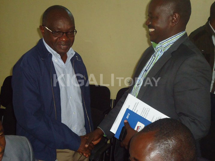Rusanganwa (ufite impapuro mu ntoki) asuhuzanya na Hon. Depite Byabarumwanzi Francois nyuma y'amatora.