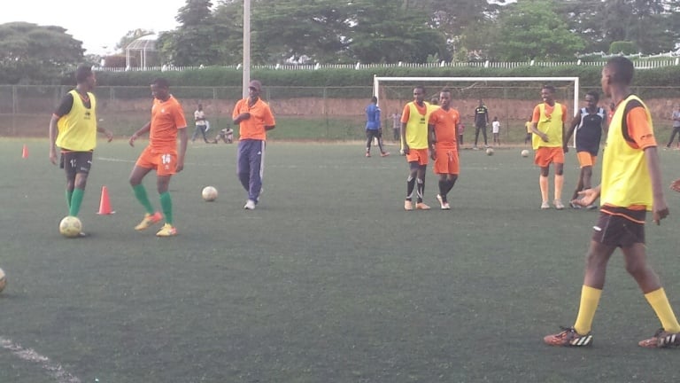 Mu myitozo, umutoza (wambaye Ingofero) w'Isonga FC ababwira uko bakinana na bagenzi babo