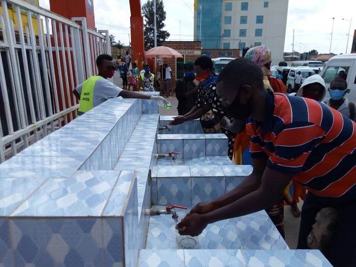 Abakorerabushake b'urubyiruko bari gufasha abagenzi gukaraba. Abagenzi na bo biyemeje kwita ku mabwiriza kugira ngo birinde batazongera guhagarikirwa ingendo