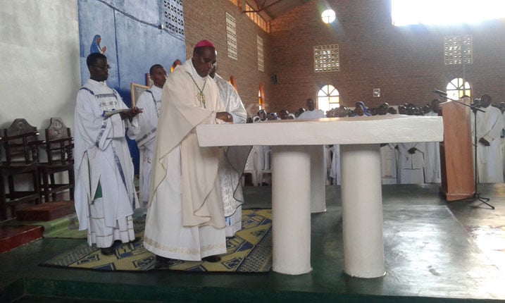 Mgr Antoine Kambanda yabanje guha umugisha aritari ayisiga amavuta.