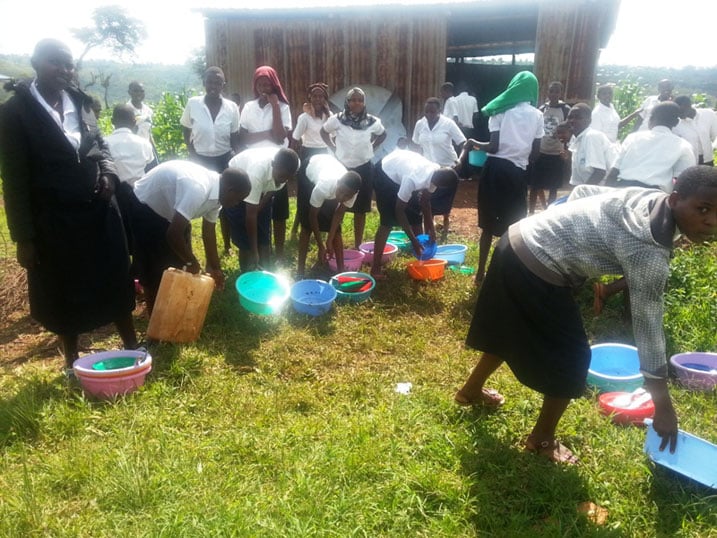 Abanyeshuri barimo koza ibikoresho byo kuriraho. Bemeza ko school feeding yabafashije.