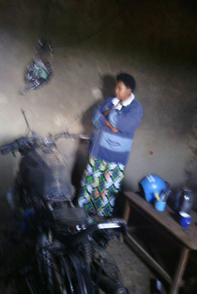 Nguwo umugore imbere ya moto yatwitse.