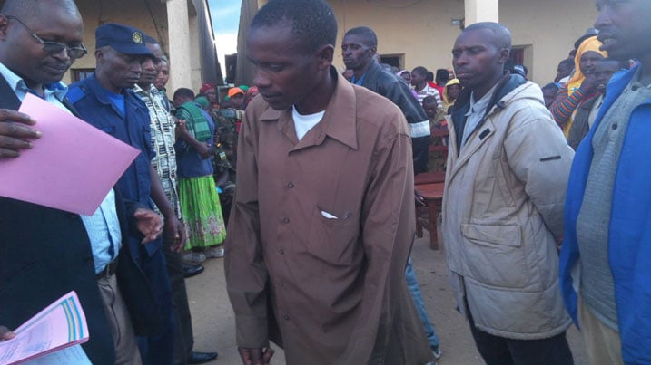 Umuyobozi w'akarere ka Nyaruguru wungirije ushinzwe ubukungu, imari n'amajyambere Niyitegeka Fabien ashyikiriza umwe mu bahoze ari Local Defense icyemezo cy'ishimwe.