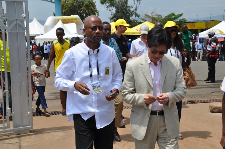 Perezida wa Ferwacy Aimable Bayingana (ibumoso) akurkirana uko isiganwa rya 2014 ritangira.