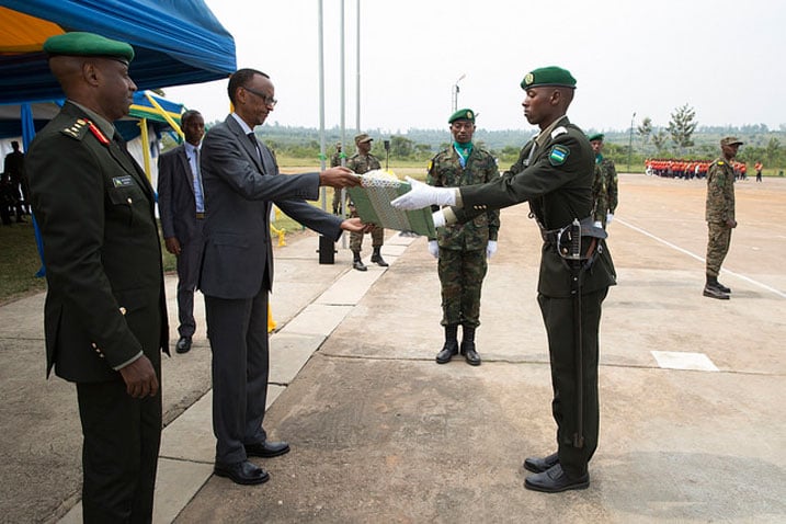 Perezida Kagame ashyikiriza ibihembo umwe mu basirikare batatu bitwaye neza mu masomo kurusha abandi.