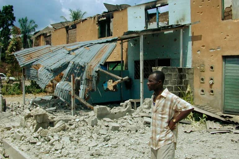 Umuturage aritegereza ibyangirikiye mu mirwano muri Congo (Ifoto: Associated Press)