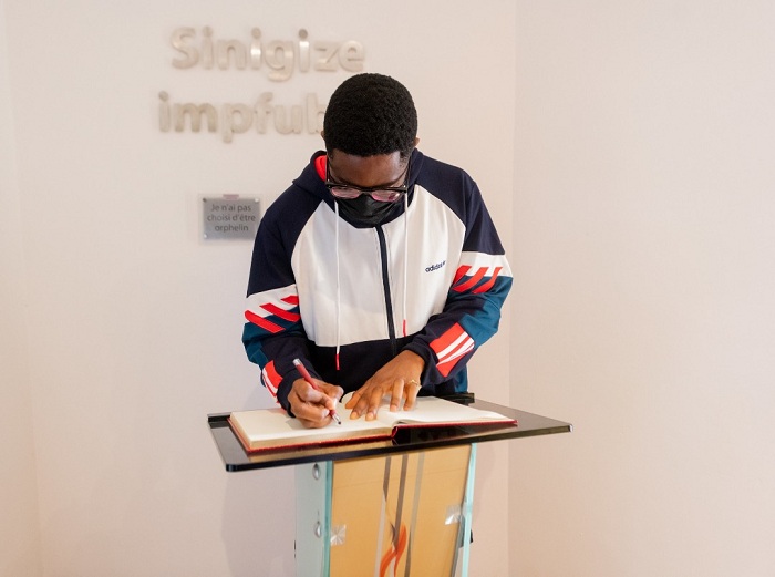 Ric Hassani yandika mu gitabo cy'abashyitsi ku rwibutso rwa Kigali