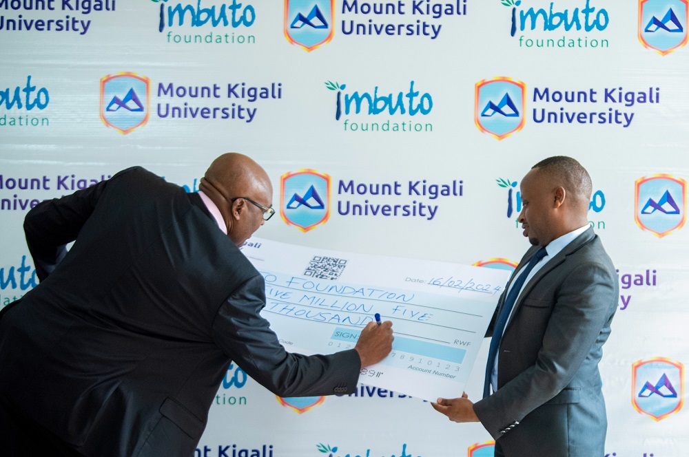 Prof. Simon N. Gicharu asinya kuri sheki ari kumwe n'umuyobozi w'agateganya wa Imbuto Foundation Vugayabagabo Jackson